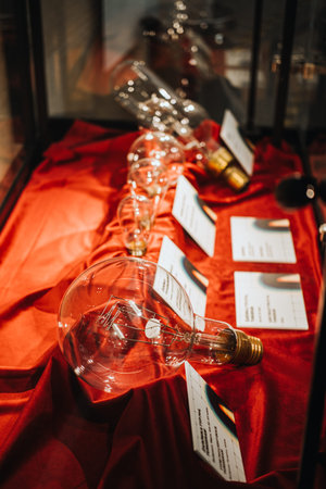 Warsaw, Poland - March 19, 2024. Oversized Light Bulb on Red Satin Fabric