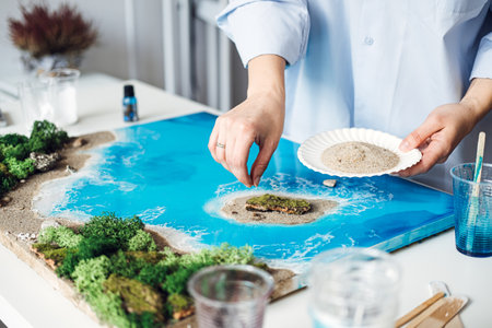 Artist Applying Final Touches to a 3D Epoxy Resin Coastal Artworkの写真素材