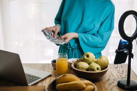 Content creator counting money during live stream, influencer marketing, financial success, digital entrepreneurship, online earnings, social media revenueの写真素材