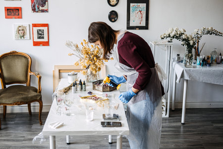 Crafting resin art with dried flowers, step-by-step process for beginners. Hands-on DIY home decor with natural elements, sustainable techniques.の写真素材