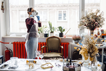 Small business owner preparing workspace, putting on protective mask for resin art creation. DIY...