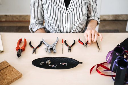 Artisan crafting workspace with jewelry-making tools. Highlighting professional craftsmanship and...
