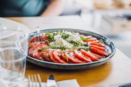 Fresh tomato salad with arugula and fennel on a rustic plate, showcasing vibrant farm-to-table dining and organic simplicityの写真素材