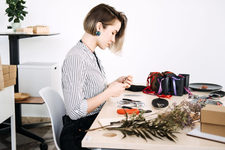 Jewelry artisan meticulously crafting handmade accessories in a modern workspace. Handmade business,...