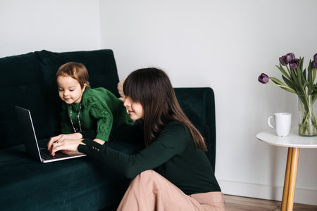 Mother and child using laptop together. Tech-savvy parenting, digital tools, online learning, screen time management, virtual workspacesの写真素材