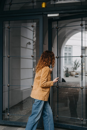 Modern woman entering smart-access workspace with mobile device. Urban flexibility, contactless...
