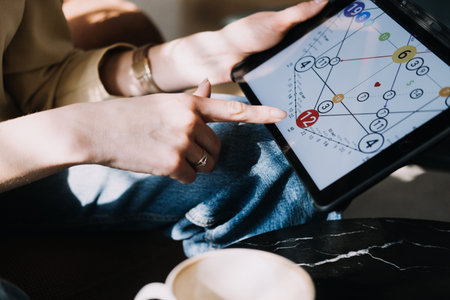 Numerologist analyzing a personal numerology chart on a tablet in a calm setting. Modern numerology,...