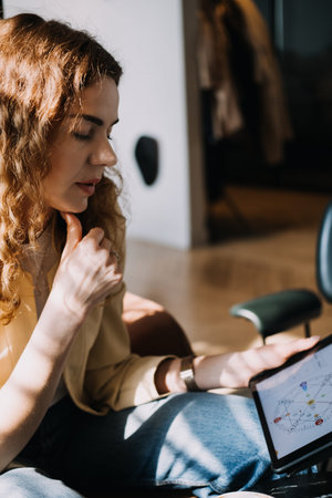 Numerologist analyzing a personal numerology chart on a tablet in a calm setting. Modern numerology,...