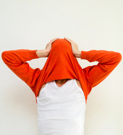 Funny portrait of man in bright sweater on head isolated on white backgroundの写真素材