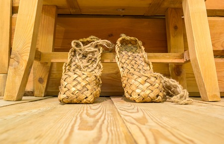 Old russian bast shoes on the wooden floorの写真素材