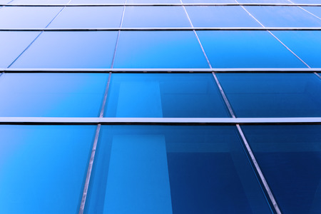 Perspective view to blue background of glass building skyscraperの写真素材