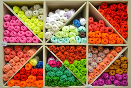 Shelf with colorful colors wool yarn balls on shop display stand for saleの写真素材