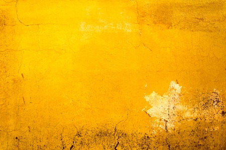 Yellow painted old dirty concrete wall texture or backgroundの写真素材