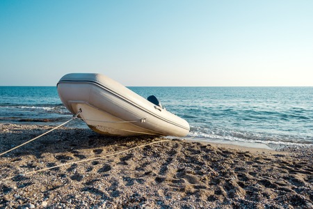 Old boat on the beach, sea and blue sky in backgroundの写真素材