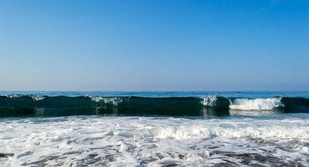 Sea waves breaking on a stony beach, forming sprays and splashesの写真素材
