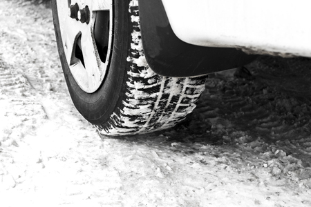 Car tyres on winter road covered with snowの写真素材