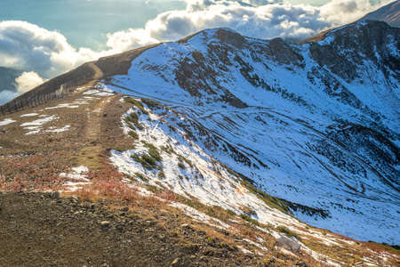 Top of snowy high mountain and clouds in the sky - sunny dayの写真素材