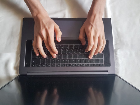 Male hands typing on laptop keyboard