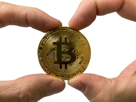Golden Bitcoin coin in man's hands isolated on white background