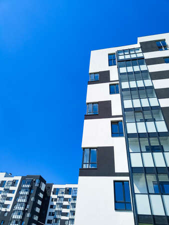 Fragment of modern apartment building opposite blue skyの写真素材