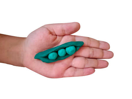 Plasticine peas on kids hand isolated on white backgroundの写真素材