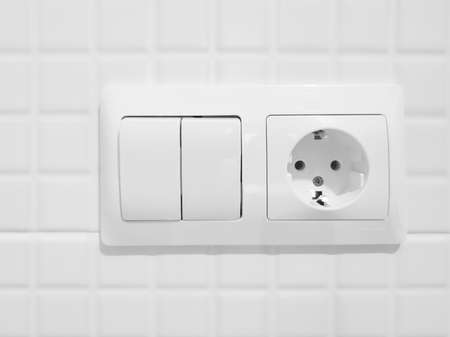 New white switch and socket on a tiled wallの写真素材