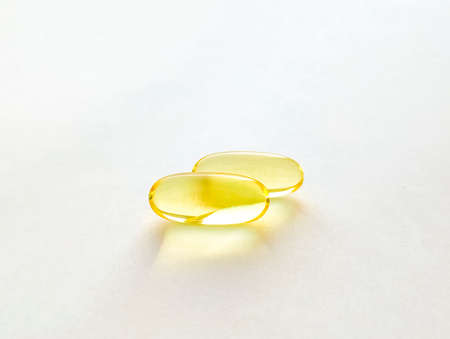 Closed capsules with dietary supplement: fish oil, omega 3, vitamin A, vitamin D, vitamin D3, vitamin E. Selective focus.の写真素材