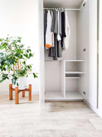 Wardrobe with basic clothes in room scandi interior. Neutral colors: white, black, beige.の写真素材