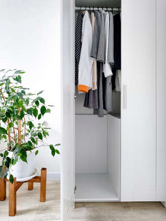 Wardrobe with basic clothes in room scandi interior. Neutral colors.の写真素材