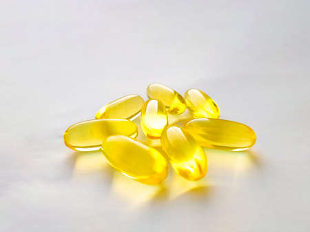 Closed capsules with dietary supplement: fish oil, omega 3, vitamin A, vitamin D, vitamin D3, vitamin E. Selective focus.の写真素材