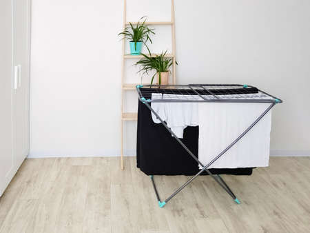 Clothes hanging on tumble dryer in room scandinavian interior.の写真素材