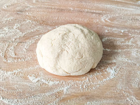 Fresh raw dough on wooden table covered with flour. top viewの写真素材