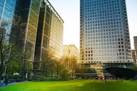 LONDON, CANARY WHARF UK - APRIL 13, 2014  - Modern glass architecture of Canary Wharf business aria, headquarters for banks, insurance, media and other world known companies  Local park view のeditorial素材