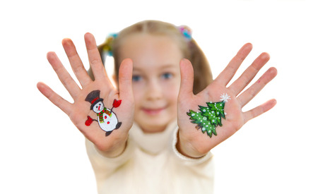 Happy girl demonstrating Christmas symbols painted on her hands. Snowman and Christmas treeの写真素材