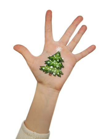 Children\'s hands with painted Christmas symbols, Christmas treeの写真素材
