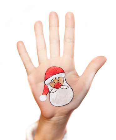 Children\'s hands with painted Christmas symbol. Santa Claus iconの写真素材