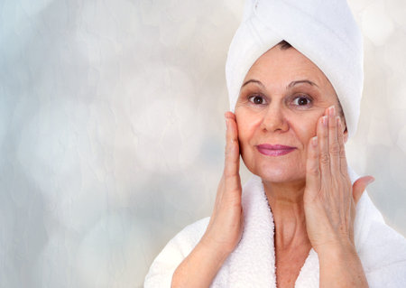 Spa concept. Aged good looking woman with white towel on her headの写真素材