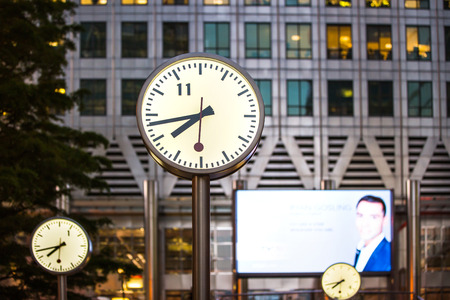 LONDON, UK - 7 SEPTEMBER, 2015: Canary Wharf business life. Clock on the main square showing quarter to eight evening timeのeditorial素材