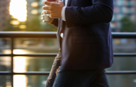Business man in suit walking against of sunset light, Londonの写真素材