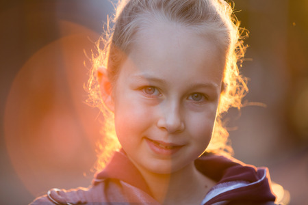 Little girl out door portrait against of sunset lightsの写真素材