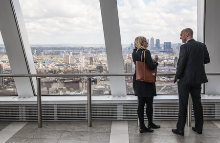 LONDON, UK - APRIL 22, 2015: Business people watching London skyline from the 32 floor of viewing hallのeditorial素材