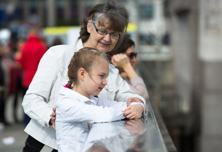 Elderly woman and granddaughter enjoying the London view. Background includes modern building City...
