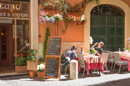 ROME, ITALY - APRIL 8, 2016:  Restaurant and people waiting to be served at the Rome's streetのeditorial素材