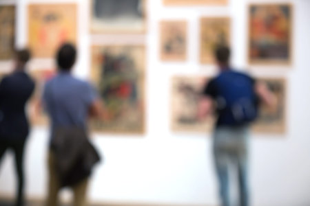 People in exhibition hall  looking a pictures, Blurred background