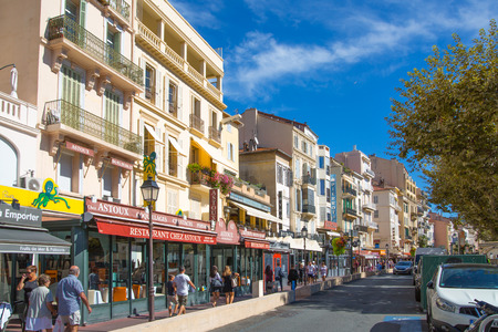 CANNES, FRANCE - 19 SEPTEMBER, 2016: Centre of the town view with restaurants, cafes and lots of walking people. Old city of Cannes colorful houses.のeditorial素材