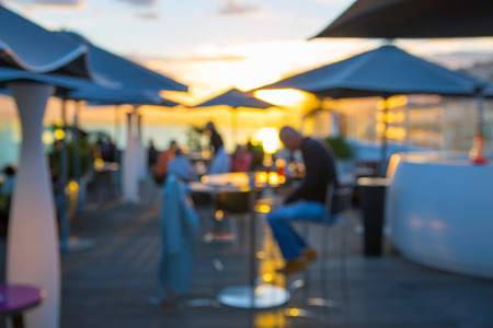 Man sitting in cafe against of sunset. Blurred image for backgroundの写真素材