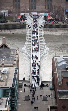 LONDON, UK - DECEMBER 19, 2016: Millennium foot bridge over the River Thames and office people walking throughのeditorial素材