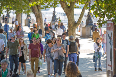 LONDON, UK - SEPTEMBER 10, 2015: Embankment of River Thames with lots walking peopleのeditorial素材