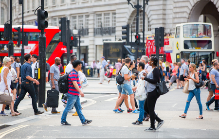 London, UK - August 24, 2016: Piccadilly circus with lots of people, tourists and Londoners crossing the junction. Red bus at the background.のeditorial素材