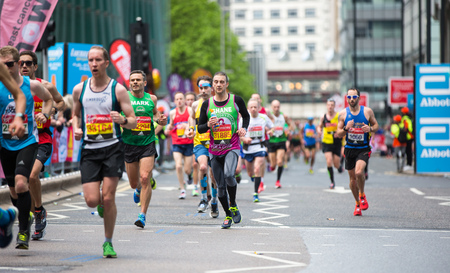London, UK - April 23, 2017: Lots of people running in London Marathon.  People cheering the sportsmen in Canary Wharf ariaのeditorial素材